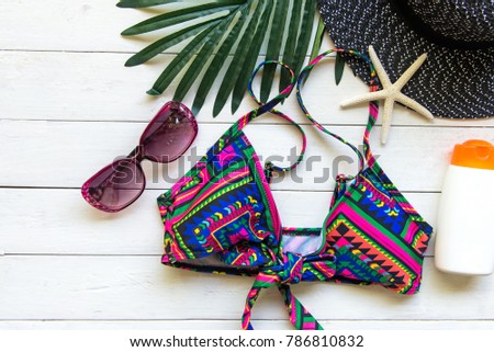 Summer Fashion woman swimsuit Bikini, camera, starfish, sunblock, sun glasses, hat. Travel in the holiday wood white background.  Summer Concept.