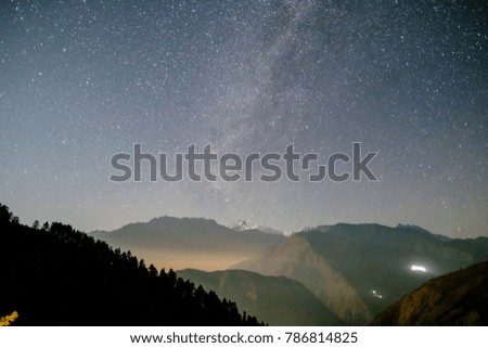 Starry sky with Milky Way galaxy in sunset light over snowy mountains in the Himalayas, Langtang, Nepal