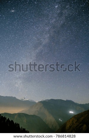 Starry sky with Milky Way galaxy in sunset light over snowy mountains in the Himalayas, Langtang, Nepal
