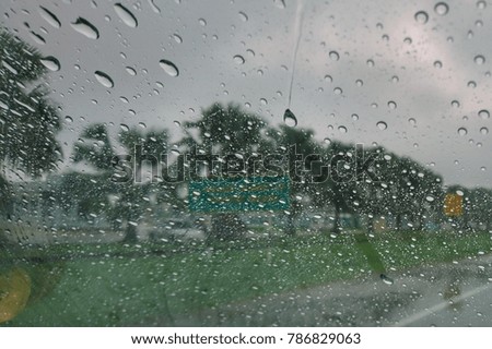 Raindrops on glass. Blurry backdrop. Rainy traffic. View from wet window.