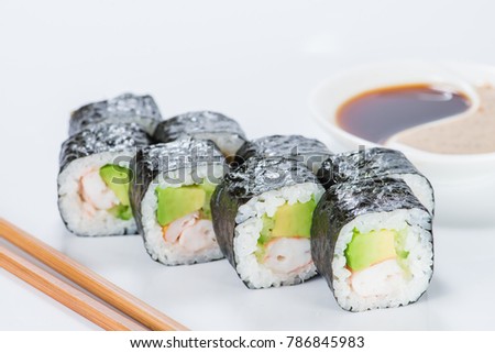 Appetizing fresh sushi rolls with rice, shrimps, avocado and cucumber on light background