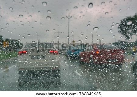 Raindrops on glass. Blurry backdrop. Rainy traffic. View from wet window.