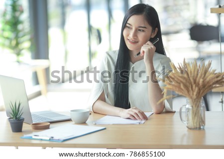 Asian business woman working in in coffee shop cafe with laptop paper work  (Business woman concept.)