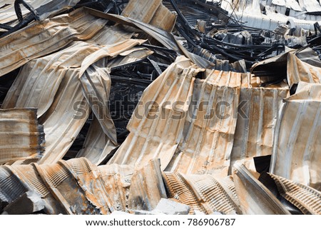 Burnt out warehouse with charred roof trusses and burnt products