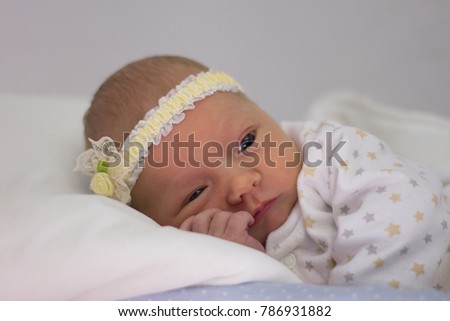 Newborn baby in a basket on a white background.