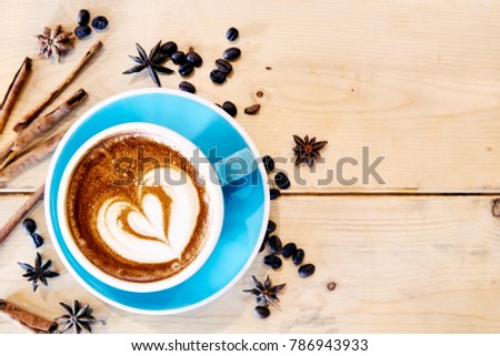 Hot coffee drawing heart in blue cup on wood texture with copy space.view from above, flat lay