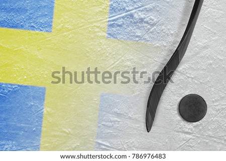Hockey puck, stick and the image of the Swedish flag on the ice. Concept, hockey