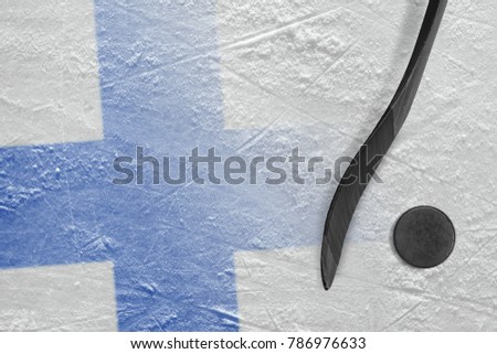 Hockey puck, stick and the image of the Finnish flag on the ice. Concept, hockey