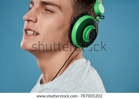  man smiling listening to music on a blue background                              