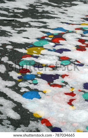 Bright pictures, circles on the asphalt covered with white snow. Winter holiday background