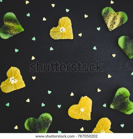 Heart of citrus with kiwi fruit on black background. Food frame. Flat lay, top view