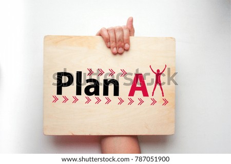 plan concept. hand of a girl holding a wooden sign with an inscription