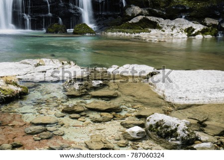 close up on green turquoise creek lake by beautiful Waterfall Virje in long exposure, Slovenia