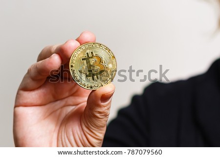 Hand holding golden bitcoin virtual money