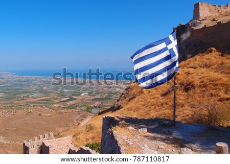 Photo of Greek waving flag in iconic castle of Acrocorinth above archaeological site of ancient Corinth, Peloponnese, Greece Royalty-Free Stock Photo #787110817