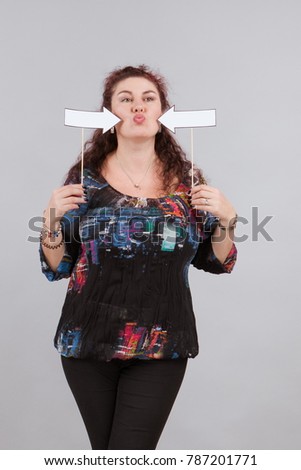A brunette woman holding arrows signs, blank form for inscriptions