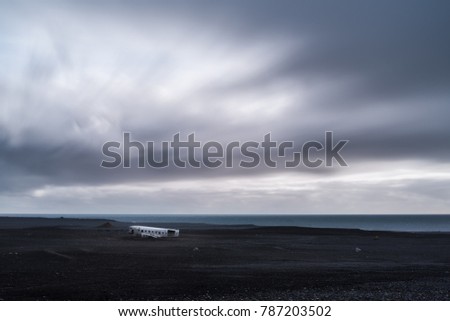 Passing rain clouds over the plane crash on a black sand beach in south Iceland 