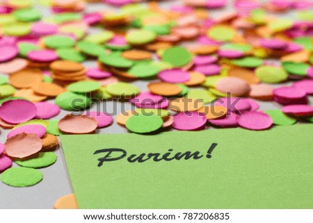 Carnaval party background concept. Space for text, copyspace. Colorful confetti spread over table. Warm colors: pink, yellow and orange. Horizontal orientation, selective focus. Purim.