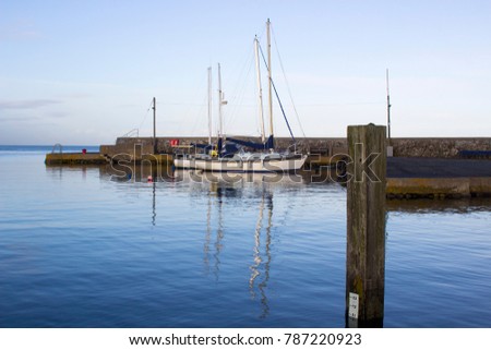 Yachts  in the calm waters of Groomsport Harbour in Northern Ireland and pictured in the soft glow of mid winter sunlight