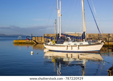 Yachts  in the calm waters of Groomsport Harbour in Northern Ireland and pictured in the soft glow of mid winter sunlight