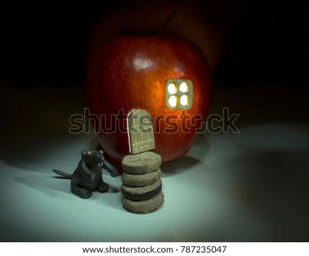 a house made of an apple with a window and a door next to a mouse