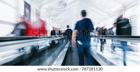 crowd of anonymous blurred people on a escalator at a trade show