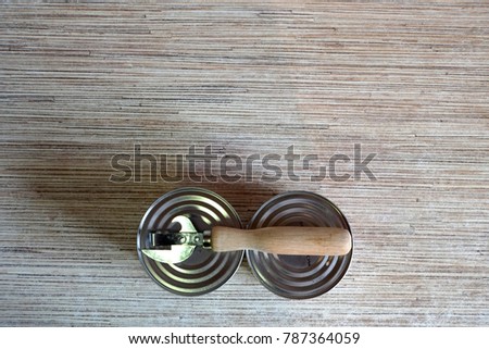 Cans. Corkscrew with a wooden handle. Wooden worktop. The view from the top. A warm light. You can use in advertising and design.