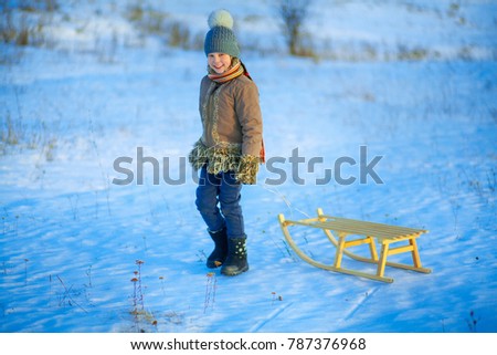 The Child playing in winter a outdoors.