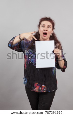 A brunette woman holding a sheet of note paper, an empty letterhead