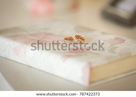 Two wedding rings on a beautiful book. Wedding details.