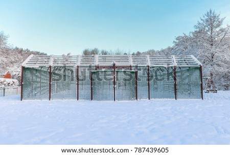 Metal basketball court construction covered in heavy snow