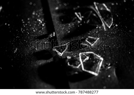 Broken pieces of glass on a black surface.
