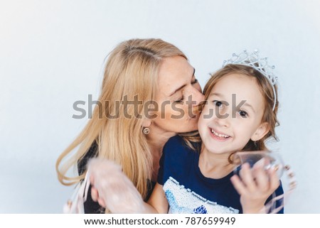 Mom kisses daughter on the check.