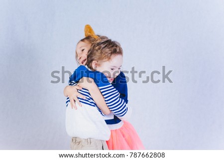 Family in studio.boy and girl hugging, girl with kitty ears, hugs. warm feelings, tenderness, care.boy with down syndrome. She is my precious treasure