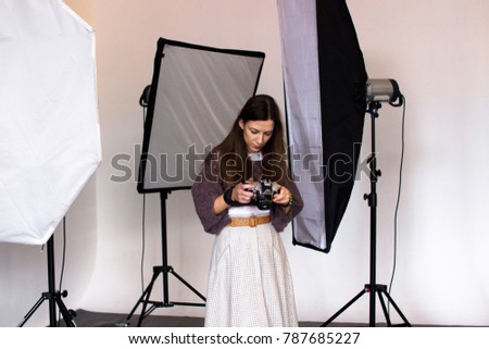 backstage photo shoot in the studio with professional equipment, the photographer scans the footage taken on the shooting on the camera screen