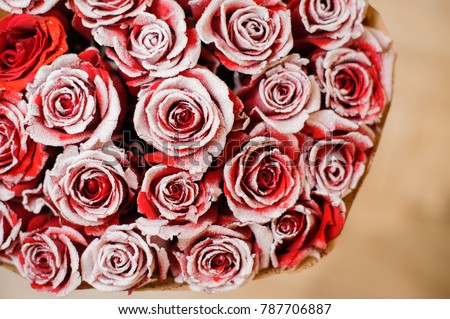 half image of round big romantic bouquet of red pion-shaped roses decorated with white powder for flowers