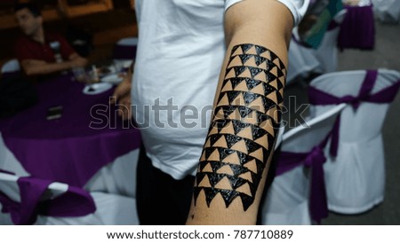 The making of Henna, creative non permanent dye on left forearm. 