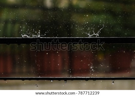 Rain drops splash on balcony rail - close up
