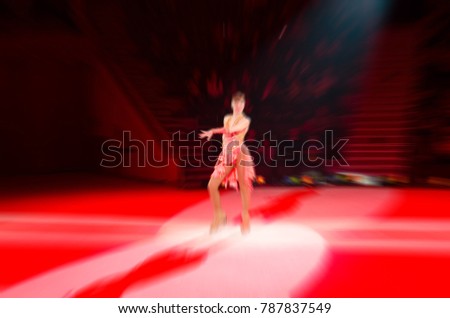 Abstract blurred image of tour of circus on ice. Actress of troupe on manege, radial blur, background 