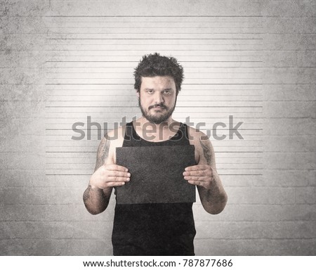Gangster in front of a wall with table on his hand.