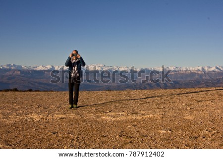 Young man taking a photo with smartfon  with the Pyrenees mountains landscape in the background