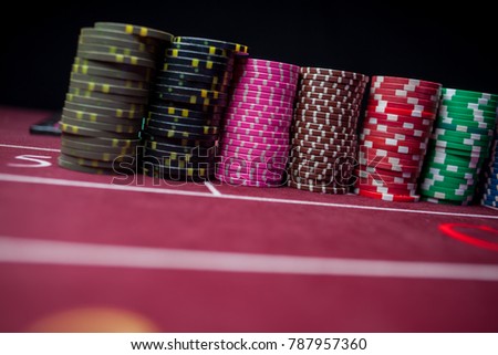 Casino / poker chips colorful gaming pieces lie on the game table in the stack. Background for gambling / casino, business, poker. Colorful casino / poker chips for casino game on the table.Soft focus