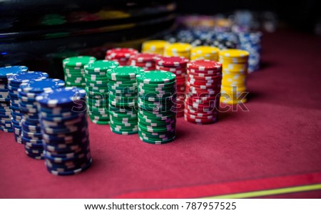 Casino / poker chips colorful gaming pieces lie on the game table in the stack. Background for gambling / casino, business, poker. Colorful casino / poker chips for casino game on the table.Soft focus