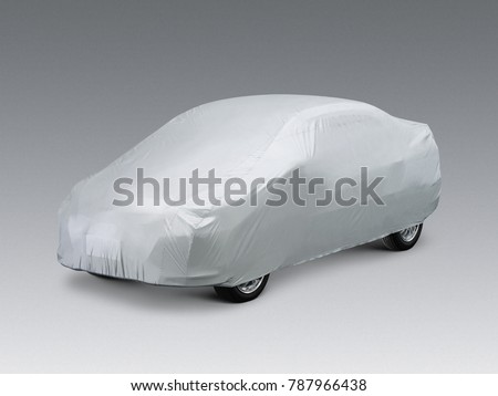 A car covered with a grey cloth, isolated on grey background. Royalty-Free Stock Photo #787966438