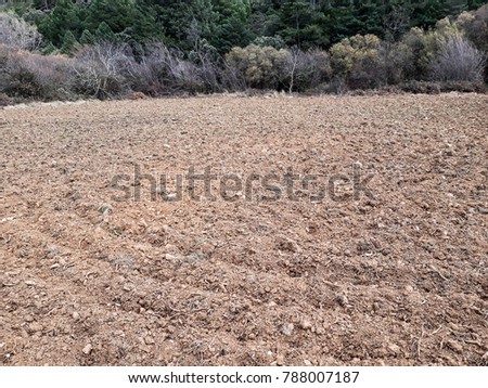 Ploughed field. Country lane through farmland