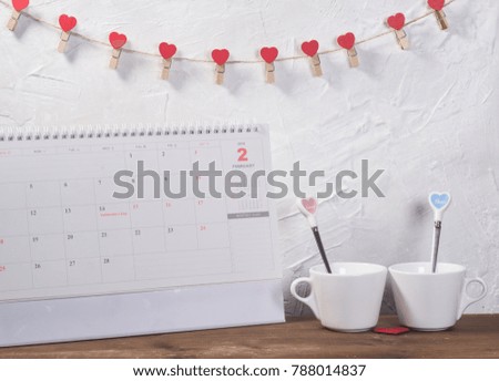 Valentine's day holiday celebration with hearts and cups over bokeh background