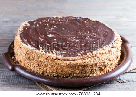 Sweet honey cake on a wooden table with with chocolate icing