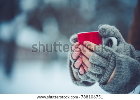 Cropped image of man holding a cup of tea outdoors in winter.