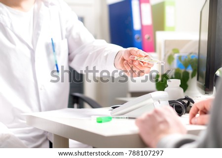 Doctor giving thermometer to sick patient with fever, flu, virus or common cold. Taking temperature in emergency room or hospital. Appointment, meeting or visit with doc. Royalty-Free Stock Photo #788107297