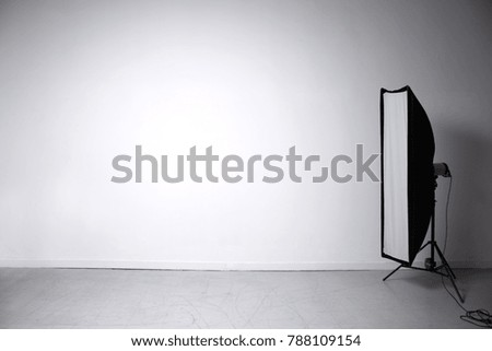 Studio light source with a strip on the background of a gray wall.